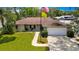 Charming home with a manicured lawn, stone accents, and an attached two-car garage at 7818 Holiday Dr, Spring Hill, FL 34606
