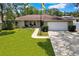 Charming single-story home featuring a manicured lawn, stone accents, and an attached two-car garage at 7818 Holiday Dr, Spring Hill, FL 34606