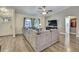 Open living area with hardwood floors, a gray sectional sofa, and large windows for ample natural light at 7818 Holiday Dr, Spring Hill, FL 34606