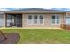 A nice backyard features a screened-in porch with neutral-colored exterior and green grass at 7822 Atwood Dr, Wesley Chapel, FL 33545
