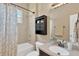 Well-lit bathroom featuring a vanity with modern fixtures and a shower with a patterned curtain and window at 7822 Atwood Dr, Wesley Chapel, FL 33545