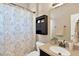 Well-lit bathroom featuring a vanity with modern fixtures and a shower with a patterned curtain at 7822 Atwood Dr, Wesley Chapel, FL 33545
