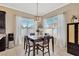 Dining area with a dark wood table, four chairs, and bright windows at 7822 Atwood Dr, Wesley Chapel, FL 33545