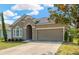 Charming home with a two-car garage, neutral color stucco and a well-manicured lawn at 7822 Atwood Dr, Wesley Chapel, FL 33545