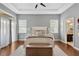 A spacious main bedroom features a tray ceiling, two windows, a ceiling fan, and an attached main bathroom at 7822 Atwood Dr, Wesley Chapel, FL 33545