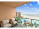 Inviting balcony with cushioned seating offers stunning views of the beach, ocean, and pool at 880 Mandalay Ave # N607, Clearwater Beach, FL 33767