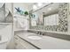 Bathroom featuring a mosaic-framed mirror and white vanity with gray countertop, with nautical-themed decor at 880 Mandalay Ave # N607, Clearwater Beach, FL 33767