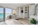 Bright bedroom featuring a cozy armchair, built-in wardrobe, and sliding glass doors to balcony at 880 Mandalay Ave # N607, Clearwater Beach, FL 33767