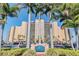 Beautiful exterior of the Regatta Beach Club with palm trees, manicured landscaping and private parking at 880 Mandalay Ave # N607, Clearwater Beach, FL 33767