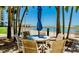 Outdoor patio seating with palm trees, tables and chairs, offering relaxation near the pool at 880 Mandalay Ave # N607, Clearwater Beach, FL 33767