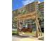 Charming wooden swing by a condo building with palm trees, offering a relaxing outdoor space at 880 Mandalay Ave # N607, Clearwater Beach, FL 33767