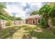 Expansive fenced backyard with well-maintained grass and mature trees, ideal for recreation and relaxation at 9466 Forest Hills Cir, Tampa, FL 33612