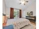 Inviting bedroom featuring neutral walls, a ceiling fan, hardwood floors, and windows with dark curtains at 9466 Forest Hills Cir, Tampa, FL 33612