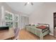 Sunlit bedroom with a ceiling fan, large windows, light wood floors, and closet space at 9466 Forest Hills Cir, Tampa, FL 33612