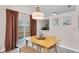 Dining area with modern lighting, view to the kitchen, and sliding glass doors at 9466 Forest Hills Cir, Tampa, FL 33612