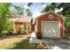 Charming home featuring an attached garage, lush landscaping, and a well maintained lawn at 9466 Forest Hills Cir, Tampa, FL 33612