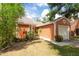 Charming exterior view of the home with an attached garage, lush landscaping, and a well maintained lawn at 9466 Forest Hills Cir, Tampa, FL 33612