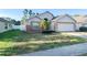 Charming single-story home featuring a two-car garage, brick accents, and a well-maintained front yard at 9735 Riverchase Dr, New Port Richey, FL 34655