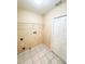 A simple laundry room features tiled floors and a wire rack for storage at 9735 Riverchase Dr, New Port Richey, FL 34655