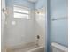 Bathroom with a white tiled shower-tub combination and neutral paint at 10205 Deercliff Dr, Tampa, FL 33647