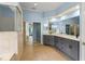 Bathroom featuring a shower, dual sinks, tile flooring, and granite countertops at 10205 Deercliff Dr, Tampa, FL 33647