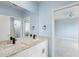 The bathroom has double sinks with stone countertops and a full mirror at 10205 Deercliff Dr, Tampa, FL 33647