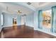 Bedroom features hardwood flooring, tray ceiling, blue walls, and windows with sheer curtains at 10205 Deercliff Dr, Tampa, FL 33647