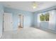 A light blue bedroom with neutral carpet, natural light, and three doors at 10205 Deercliff Dr, Tampa, FL 33647