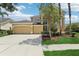 Two-story home with a tan exterior, attached two car garage, and mature landscaping at 10205 Deercliff Dr, Tampa, FL 33647