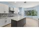 Bright kitchen features white cabinets, gray countertops, and a view of the backyard at 10205 Deercliff Dr, Tampa, FL 33647