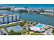 Scenic aerial view showcasing the community's waterfront location, tennis courts, clubhouse, and pool at 10216 Regal Dr # 409, Largo, FL 33774