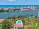 Aerial view of a condominium complex featuring a pool and lush landscaping by the water at 10216 Regal Dr # 409, Largo, FL 33774