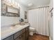 Bathroom featuring a decorative mirror, wood-style vanity and shower curtain at 10216 Regal Dr # 409, Largo, FL 33774