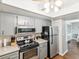 Well-lit kitchen featuring stainless steel appliances, and grey countertops and cabinetry at 10216 Regal Dr # 409, Largo, FL 33774