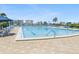Relaxing swimming pool at the community, featuring tiled patio, poolside furniture, and community views at 10216 Regal Dr # 409, Largo, FL 33774
