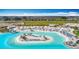 Stunning aerial view of the lagoon, community restaurant, sandy beaches, and water activities at 11291 Cay Spruce Way, San Antonio, FL 33576