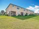 Exterior view of the back of townhomes with green grass and screened in patios at 11291 Cay Spruce Way, San Antonio, FL 33576