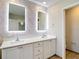 Contemporary bathroom with a double sink vanity, lit mirrors, and stylish wallpaper at 11291 Cay Spruce Way, San Antonio, FL 33576