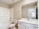 Bathroom features white vanity with quartz countertop, bathtub with showerhead, and a large mirror at 11291 Cay Spruce Way, San Antonio, FL 33576