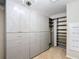 Spacious walk-in closet with custom shelving and drawers, illuminated by a chandelier at 11291 Cay Spruce Way, San Antonio, FL 33576