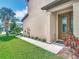 Front entrance featuring a decorative glass door, a well-maintained lawn, and tidy landscaping at 11291 Cay Spruce Way, San Antonio, FL 33576