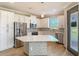 Bright kitchen with island, white cabinets, stainless steel appliances, and wood-look flooring at 11291 Cay Spruce Way, San Antonio, FL 33576