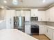 Open kitchen with white cabinets, stainless steel appliances, and quartz countertops at 11291 Cay Spruce Way, San Antonio, FL 33576
