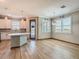 Bright kitchen with island, white cabinets, stainless steel appliances, and wood-look flooring at 11291 Cay Spruce Way, San Antonio, FL 33576