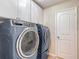 Well-equipped laundry room featuring a modern washer and dryer set with white storage cabinets at 11291 Cay Spruce Way, San Antonio, FL 33576