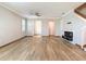 Spacious living room with wood-look floors, ceiling fan, and fireplace at 11291 Cay Spruce Way, San Antonio, FL 33576