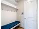 Mudroom with white wainscoting, bench seating, hooks, and shelving for convenient storage at 11291 Cay Spruce Way, San Antonio, FL 33576
