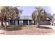 Inviting single-story home with a cozy front porch, palm trees, and an attached garage, offering curb appeal at 11807 Addison St, Spring Hill, FL 34609