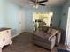 Cozy living room with wood floors, ceiling fan, and view into the bright kitchen at 11807 Addison St, Spring Hill, FL 34609