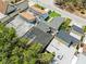 Aerial view of rooftops featuring varying materials, like brown tiles and gray shingles, surrounded by lush greenery and neighborhood streets at 12516 Cobble Stone Dr, Hudson, FL 34667